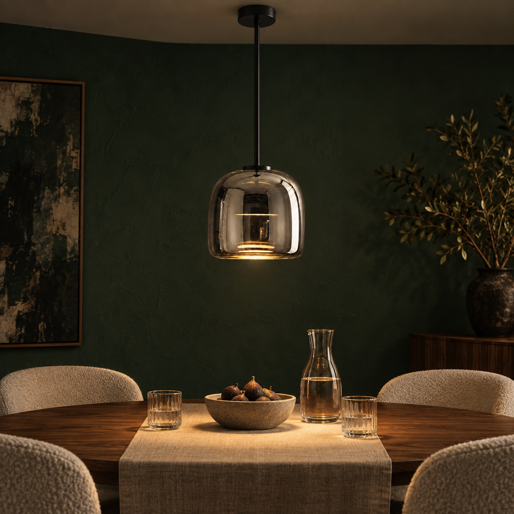 Ostara pendant light lit above a walnut dining table against a forest green wall
